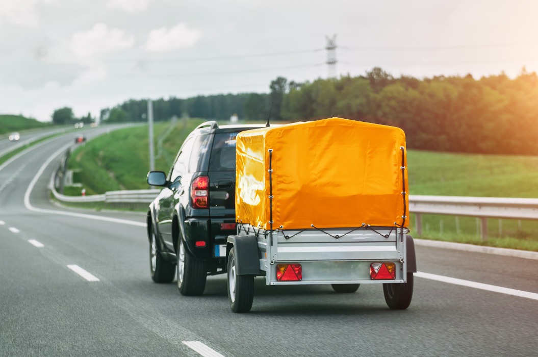 Ein SUV und ein Miet-Anhänger auf einer Straße. Effizienter Transport.